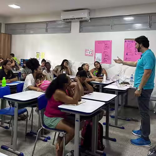 Dr. Ricardo Caiado em palestra para um grupo de mulheres, em uma sala de aula da comunidade